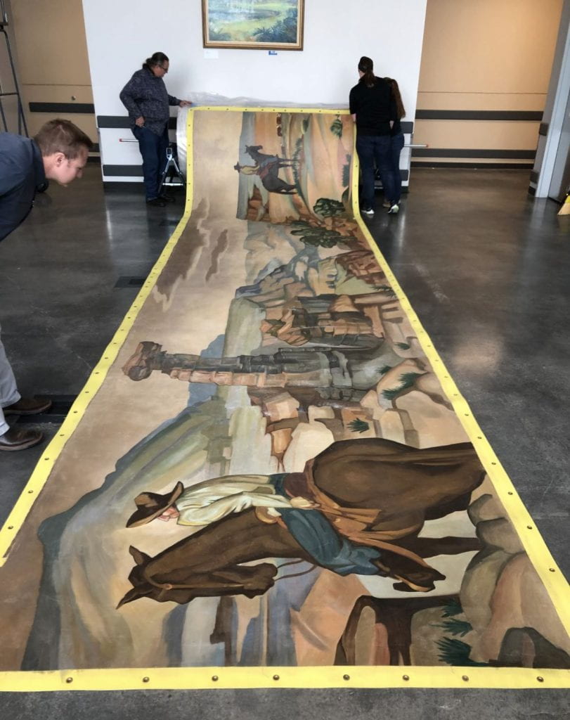 Staff inspect mural at arrival to Alkek Library